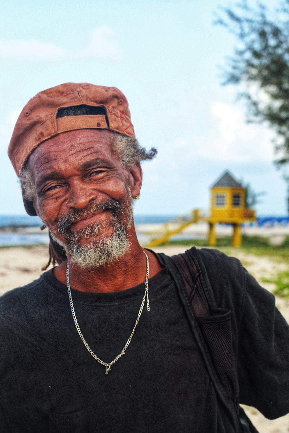 An older man smiling on a beach in Barbados