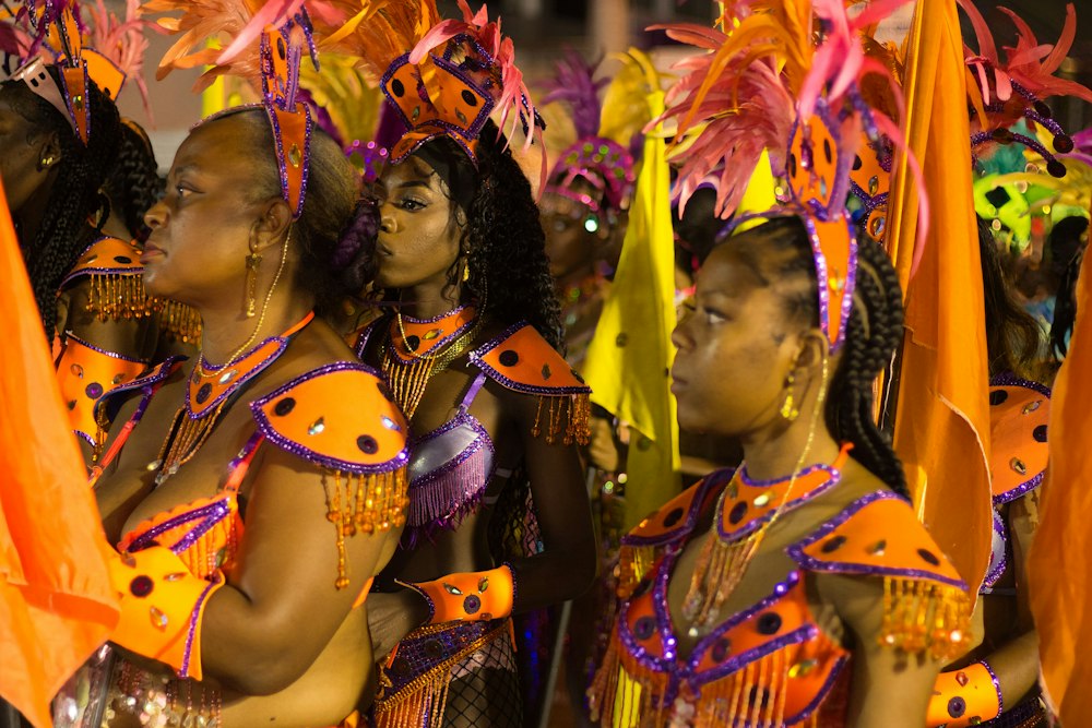 Masqueraders in orange and purple costumes at Carnival in Chaguanas